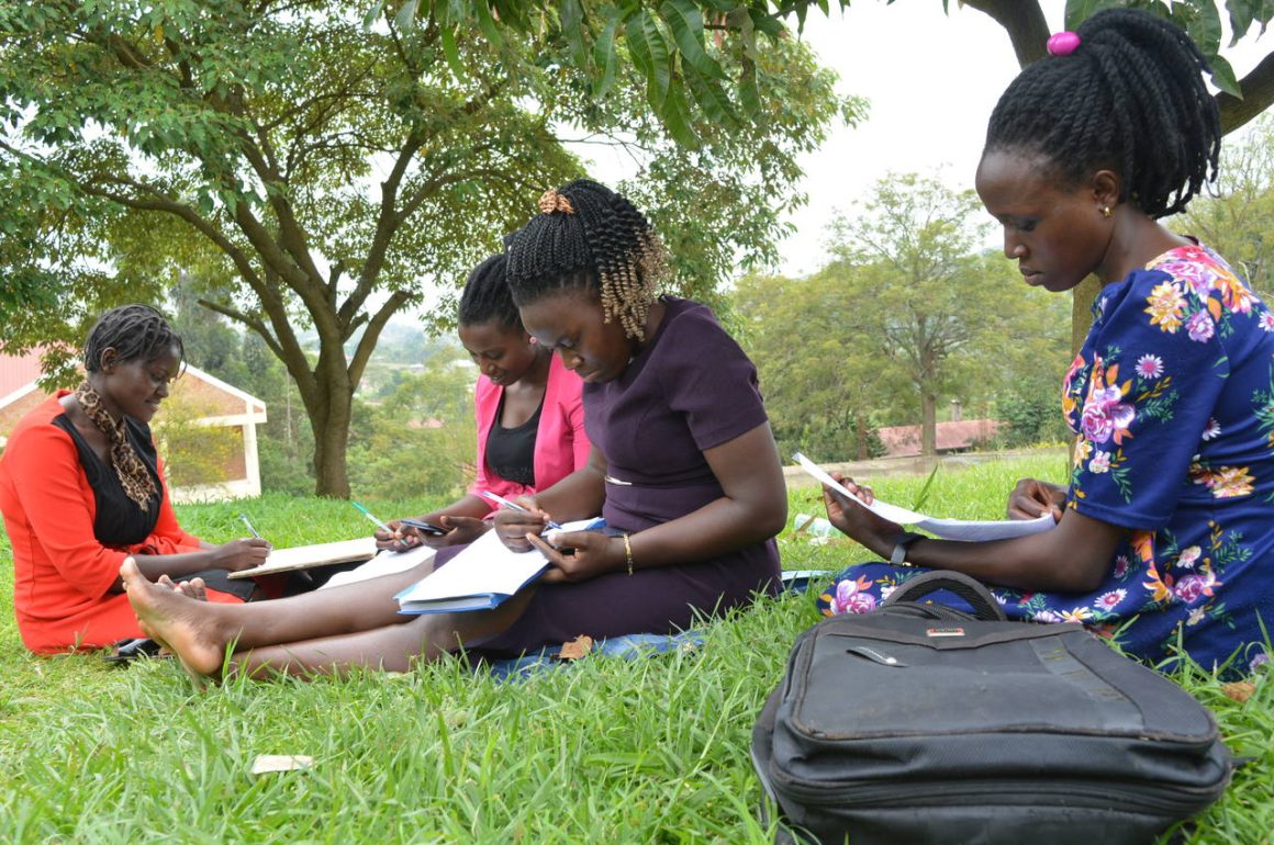 Undergraduate students engaged in a discussion group in gardens above the Faculty of Education, Arts and Media Studies, Bishop Stuart University