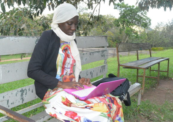 A female student with a laptop near the Department of Computing Library and Information Technology, behind Lab C, BSU on 3rd May 2022