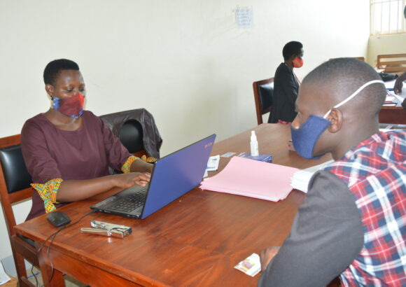 A male fresh student (August Intake AY 2021/22 ) being registered by the Assistant Registrar, Mrs. Nsiime Viola on 21st October 2021, Business Block, Level 1, Main Campus, Mbarara, Uganda