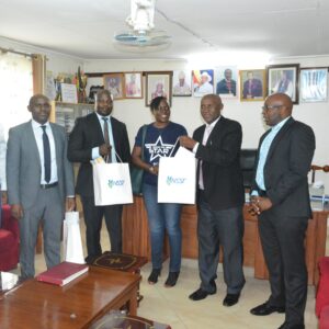 The Ag. Vice-Chancellor, Assoc. Prof. Gershom Atukunda (2nd-R) joined by CPA. Isaac Muzoora, Finance Officer (L) receive presents from NSSF team.